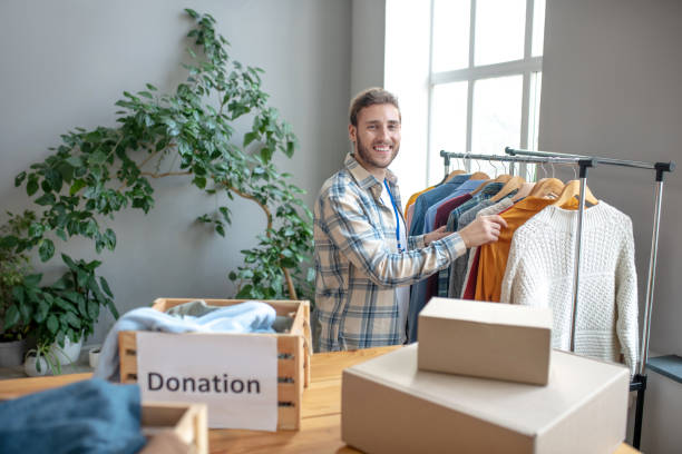 istock Young man standing at a rack with clothes. 1202789827