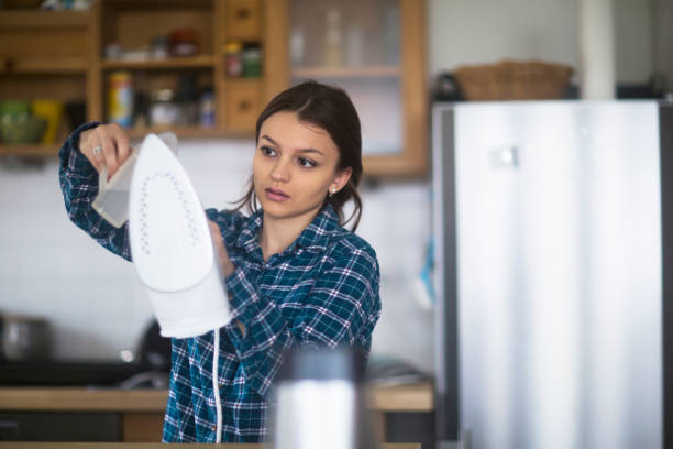 jovem mulher preparando ferro em casa - kitchen untensil - fotografias e filmes do acervo