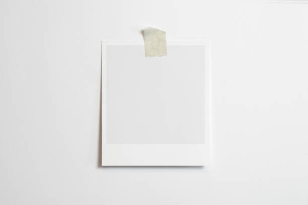 istock Blank polaroid photo frame with soft shadows and scotch tape isolated on white paper background as template for graphic designers presentations, portfolios etc. 1202792326