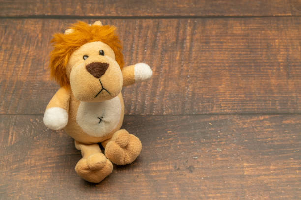 stuffed animal lion sitting on wooden