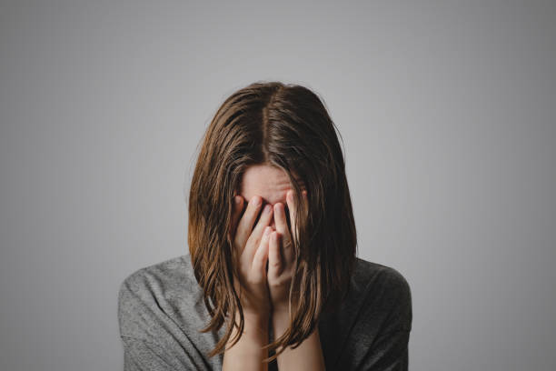 Woman covers face in hands Concept of despair, depression, loss or mental condition obscured face stock pictures, royalty-free photos & images