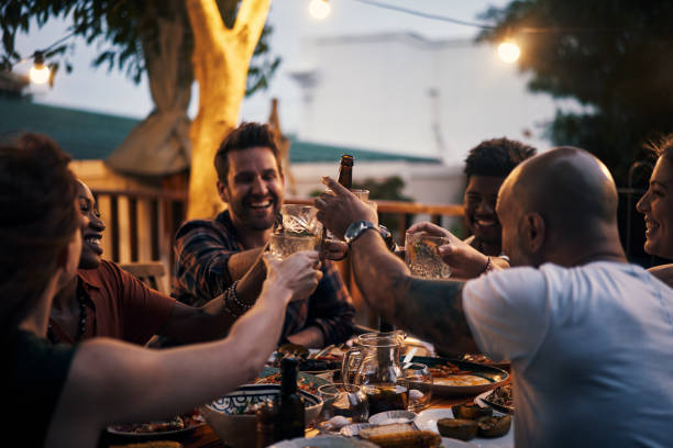 Give thanks to good friends Shot of a group of young friends toasting with drinks at a dinner party outdoors south african braai stock pictures, royalty-free photos & images