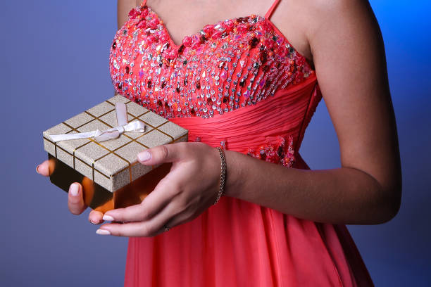 istock woman's hands holding small golden gift box 1202793594