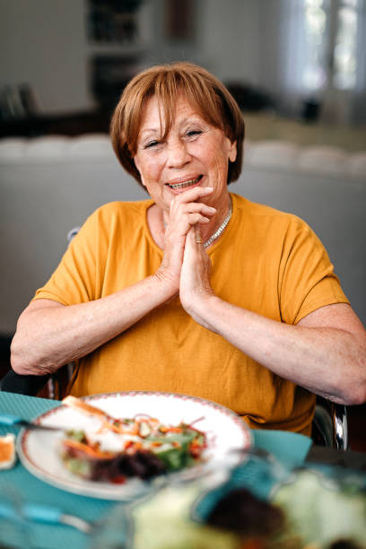 donna anziana durante la colazione a casa di riposo - 60s senior adult breakfast cheerful foto e immagini stock