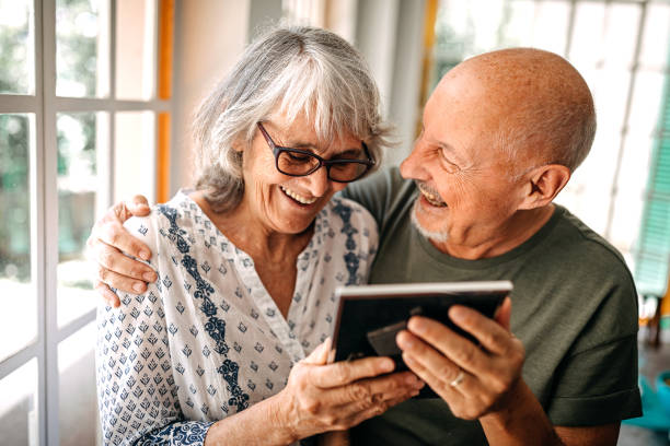istock Senior couple looking at picture frame at home 1202793931