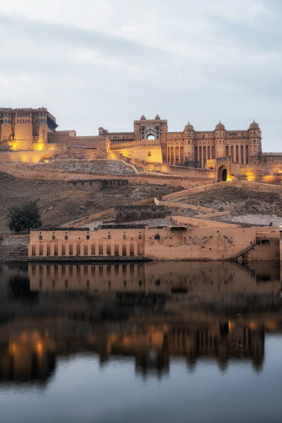 sunset over amer fort Sunset view over amer fort or amber fort taken across from maotha lake. Amer fort, Jaipur, India amber fort stock pictures, royalty-free photos & images