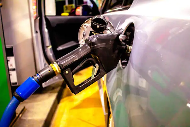 Photograph of a car being refueled at a gas station ( posto de gasolina).