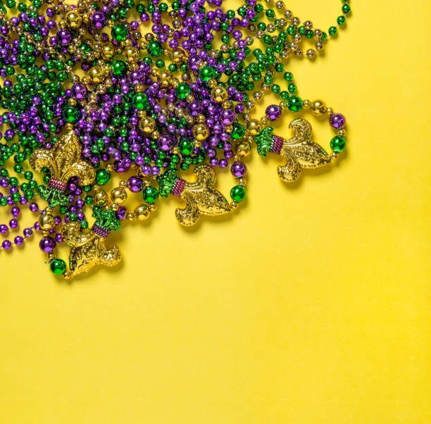 istock Mardi gras carnival decoration beads yellow background 1202802816