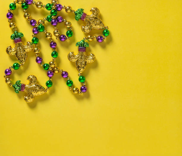 istock Mardi gras carnival decoration beads yellow background 1202802840