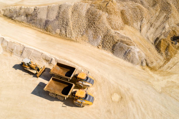 dump trucks and bulldozer in a quarry, aerial view - industrial equipment trackhoe construction site construction vehicle imagens e fotografias de stock