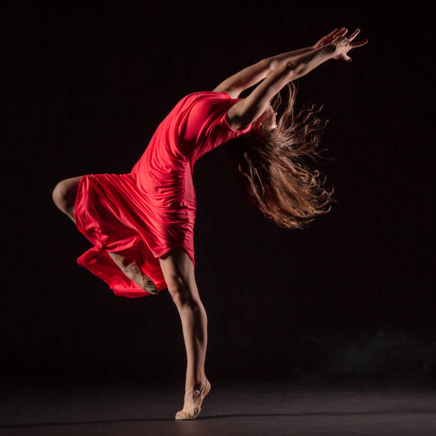istock Dancer in red dress on black background 1202808380
