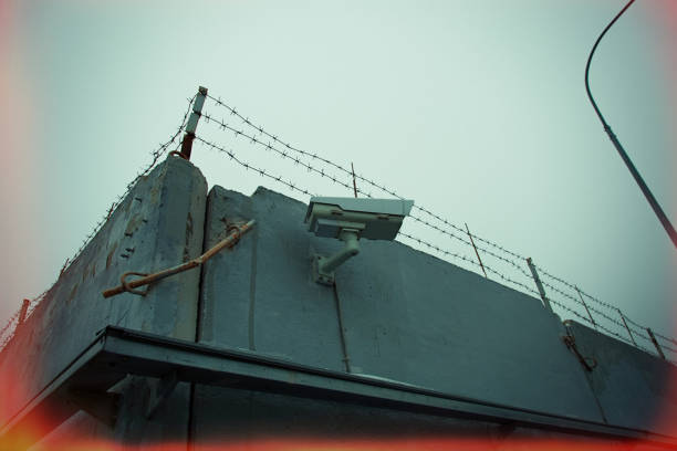 istock Barbed wire on a gray concrete fence 1202808883