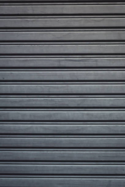 istock Metallic roll up door. Old Steel rolling shutter background. Metal security shutters protecting a small shop. 1202809850