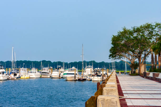 Sidewalk at a Lakefront park next to a fully occupied marina near Beaufort, SC stock photo