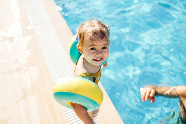 feliz risa niña niña divirtiéndose en una piscina - bebe bañandose fotografías e imágenes de stock