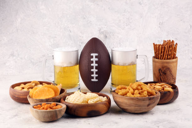 istock Chips, salty snacks, football and Beer on a table. Great for Bowl Game snack projects. 1202810466