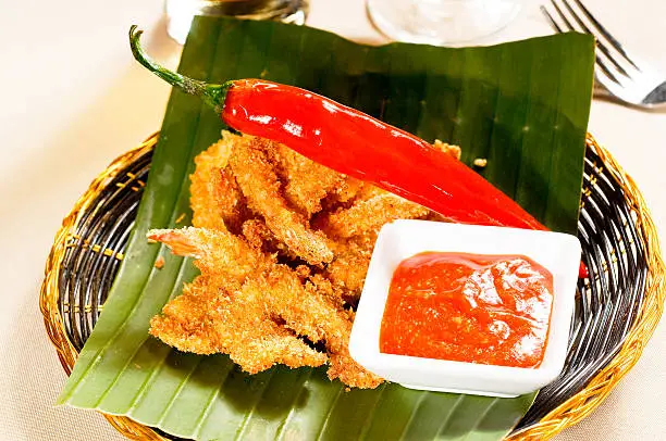 deep fried buffalo shrimps on a rattan basket with ketchup closeup