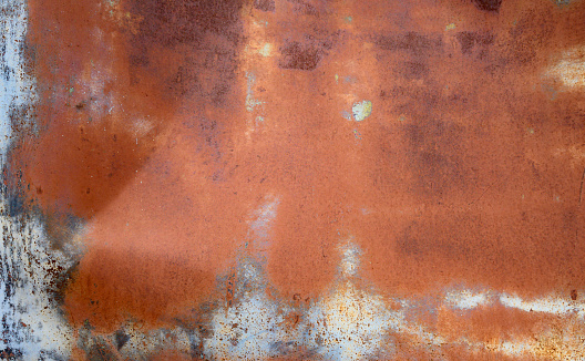 This is an abstract color photograph of a distressed metal background from a vintage car in the desert of Namibia, Africa.