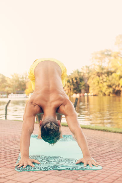 istock Young man practicing yoga outdoors 1202816275