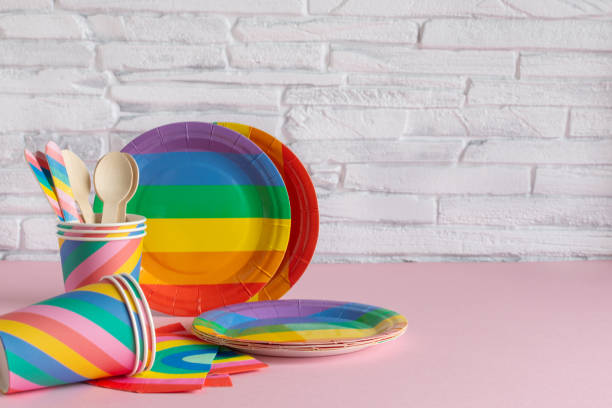 istock Rainbow colored disposable eco tableware on pink color background. Birthday party accessories,picnic utensil concept. 1202816452