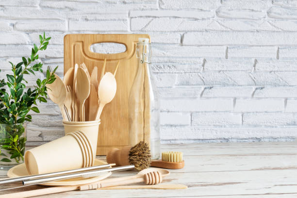istock Eco-friendly kitchenware on wooden background over white brick wall. . Tableware, brushes, spoons and bottles. 1202816460