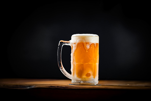 pint of Lager, shallow focus, against aged wood background.