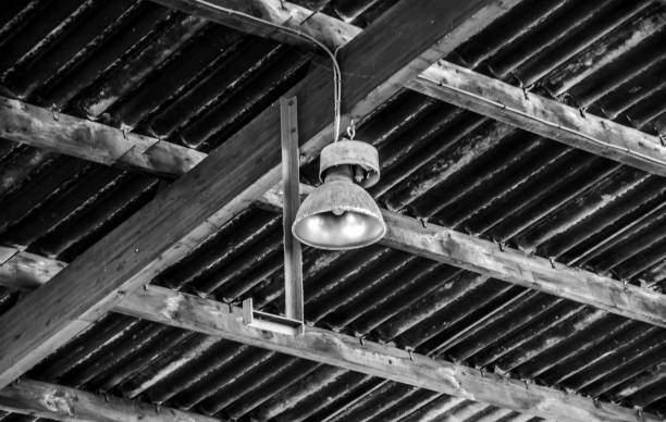 istock A lamp hanging from a corrugated ceiling with woodwork in an industrial setting 1202817270
