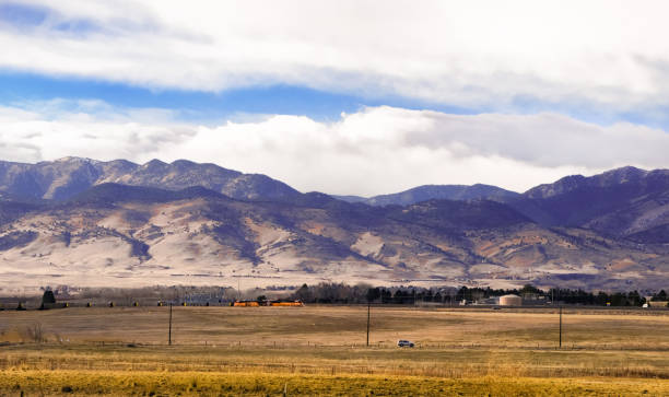 istock Colorado plains with mountains and train in background 1202819743