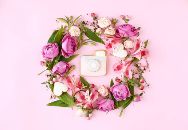 istock Photo camera shaped cookie with flat lay floral frame wreath. 1202820989