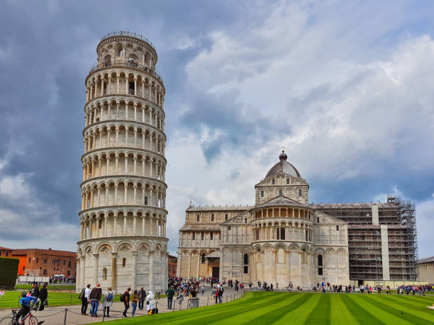 Leaning tower and cathedral of Pisa Many visitors and tourists are near the leaning bell tower at the square of Miracles in Pisa. blind arcade stock pictures, royalty-free photos & images