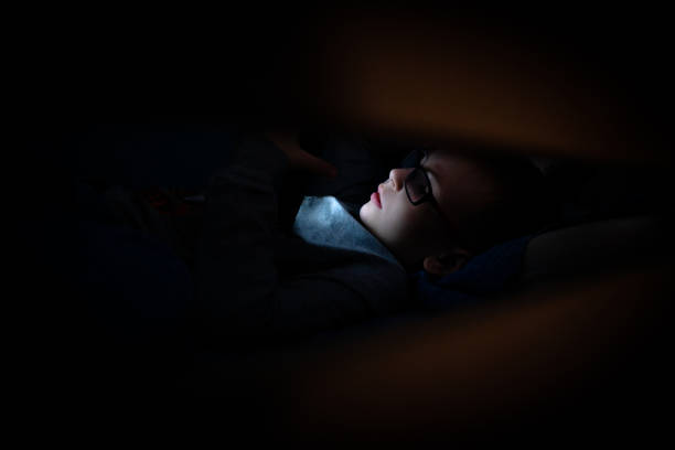 istock A little boy is looking at screen in bedroom 1202823130