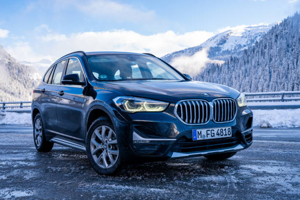 Brand new black BMW X1 SUV 2020 parked in Switzerland Brand new black BMW X1 SUV 2020 parked in Switzerland by the highway with beautiful winter mountains in the background. bmw stock pictures, royalty-free photos & images
