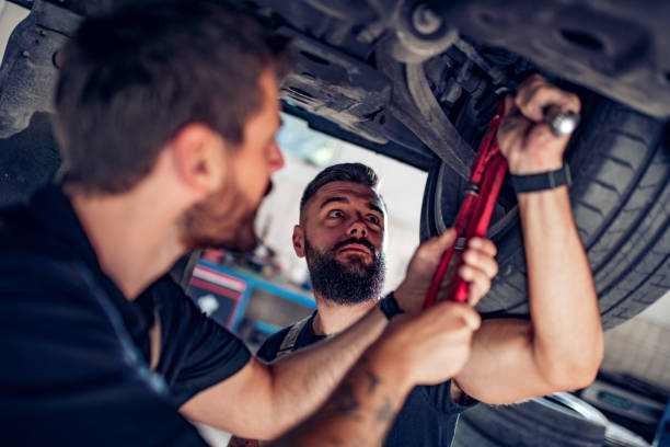 istock Two mechanics repairing car in service center 1202825164