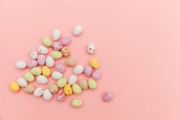 istock Happy Easter concept. Easter candy chocolate eggs and jellybean sweets isolated on trendy pastel pink background. Simple minimalism flat lay top view copy space 1202826021