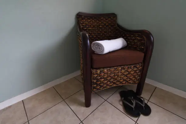 Photo of Rattan Armchair With Clean Towel And Shower Slippers