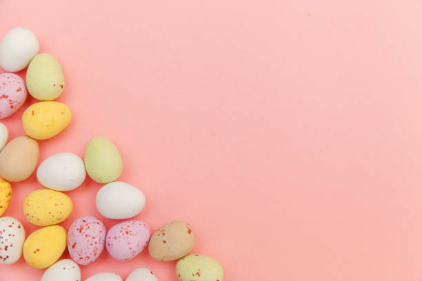 istock Happy Easter concept. Easter candy chocolate eggs and jellybean sweets isolated on trendy pastel pink background. Simple minimalism flat lay top view copy space 1202826106
