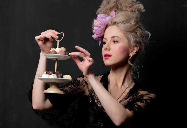 красивая блондинка графиня с шоколадными конфетами - baroque style costume corset women стоковые фото и изображения