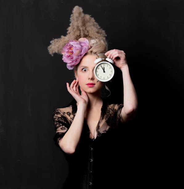 istock Beautiful blonde countess with alarm clock 1202826595