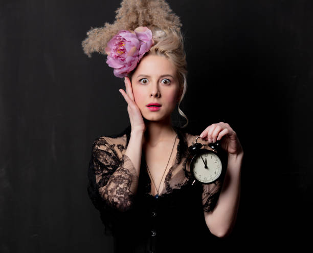 istock Beautiful blonde countess with alarm clock 1202826603
