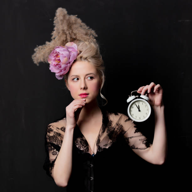 istock Beautiful blonde countess with alarm clock 1202826611