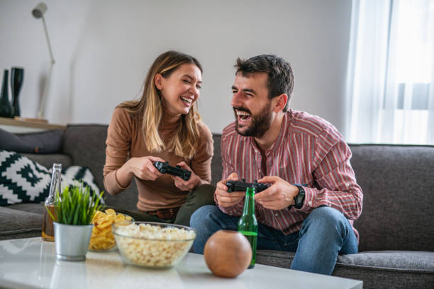 Couple enjoying their free time at home,playing video games stock photo