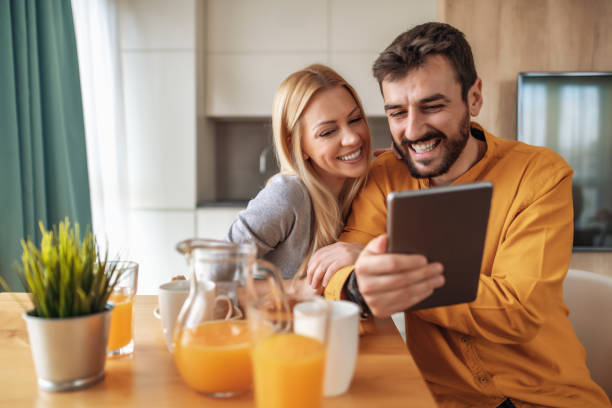 Portrait of happy couple having breakfast at home stock photo