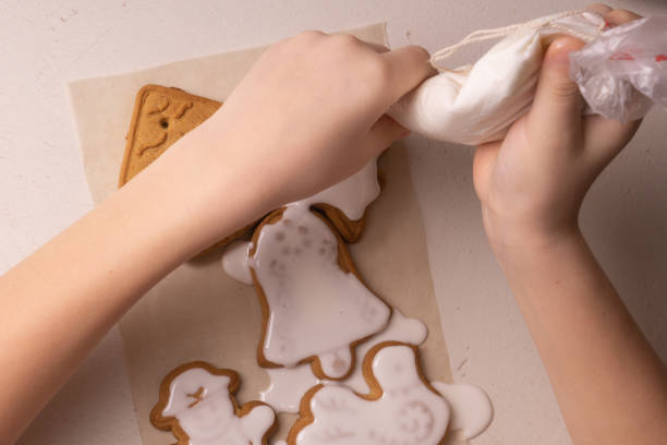 istock A 10-year-old boy glazes cookies with a culinary bag. Handmade. Children's creativity. 1202831034