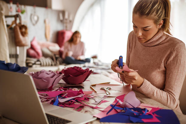 istock Young creative woman using hot glue gun on her crafting project 1202845517
