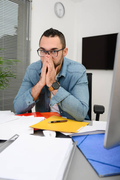 istock handsome man in office busy stressed headache paperwork burnout 1202847079