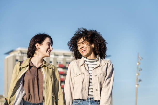 istock two women walking around the city laughing 1202847219