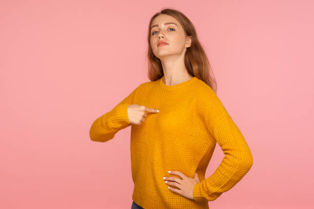 This is me! Portrait of attractive haughty ginger girl in sweater pointing at herself and looking at camera with arrogance This is me! Portrait of attractive haughty ginger girl in sweater pointing at herself and looking at camera with arrogance, proud and confident in success. studio shot isolated on pink background bossy stock pictures, royalty-free photos & images