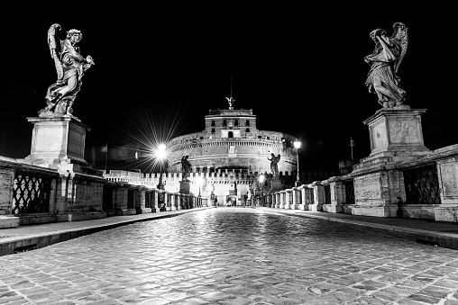 Castel Sant Angelo night view from Ponte Sant Angelo, Rome, Italy. Black and white image.