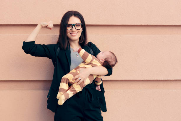 mujer fuerte en el traje de negocios sosteniendo bebé - mother superior fotografías e imágenes de stock
