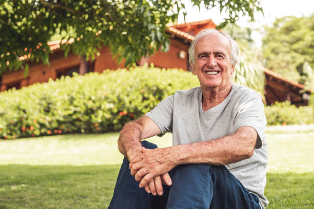istock Elderly man sitting on the grass 1202856453